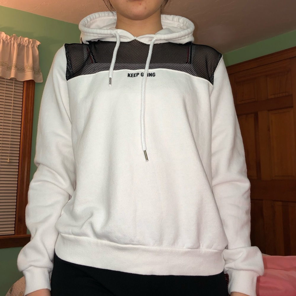 A women's white hooded shirt. The top part is sheer fishnet styled.
